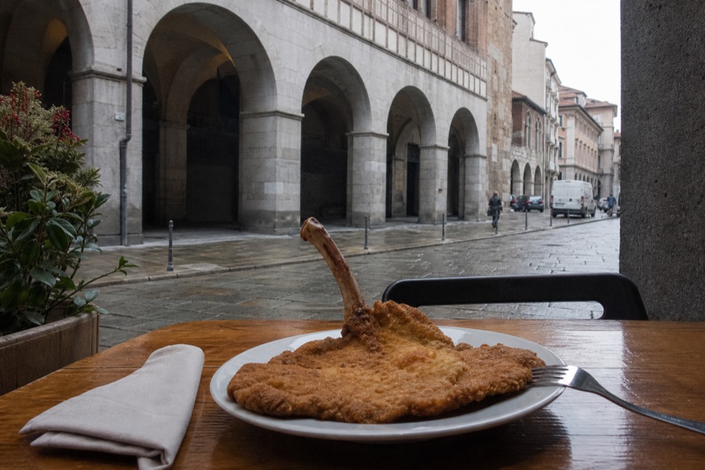 A menu page showing cotoletta alla milanese listed with its De.Co. recognition text