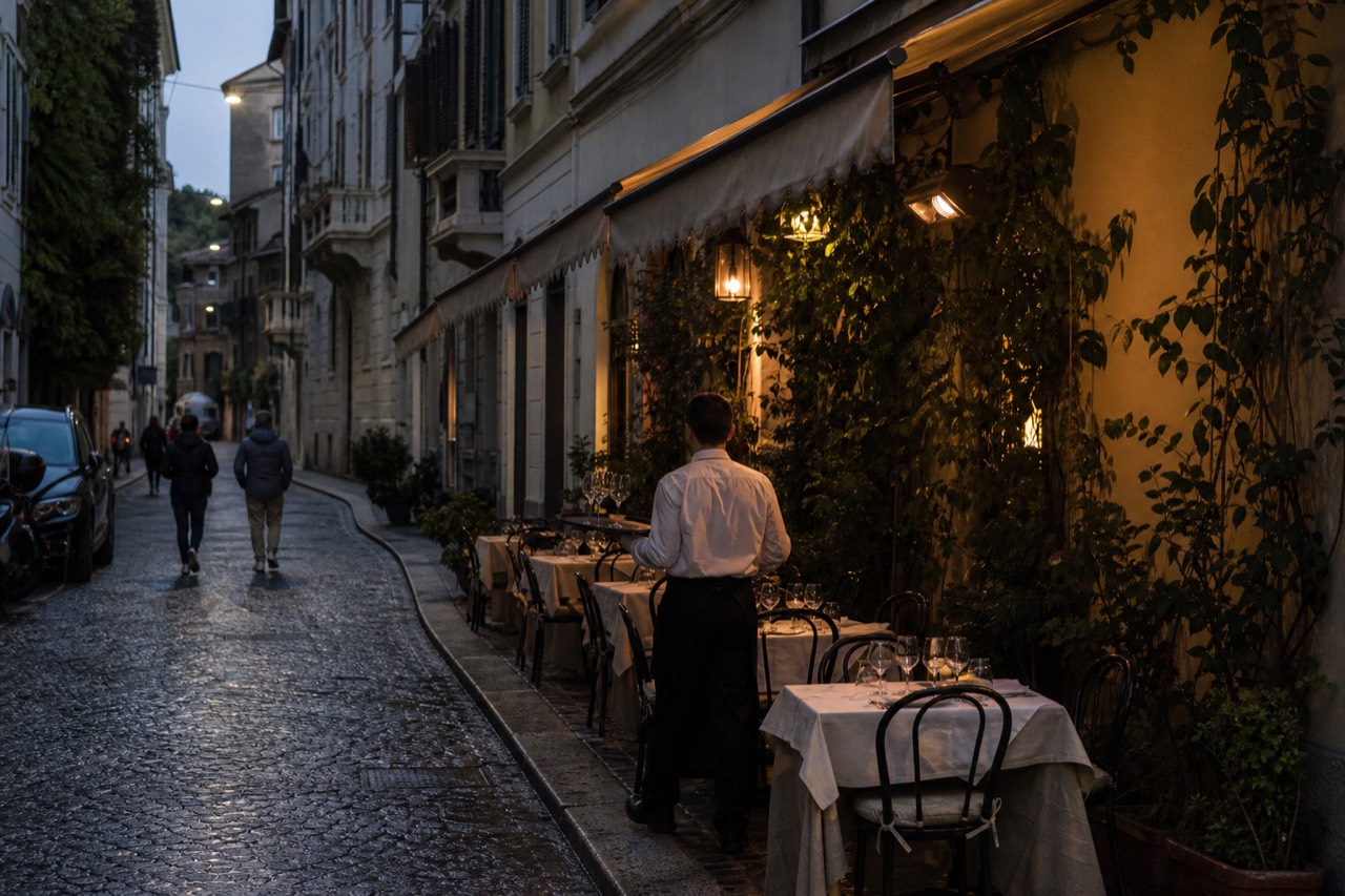 Cobbled Brera street with restaurant tables set out under evening light