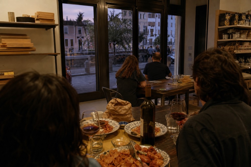 A family table set with plates of homemade pasta and glasses of wine