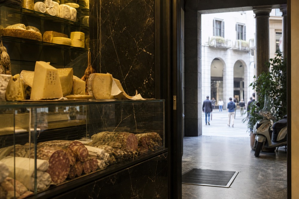 Glass counters of cheese and cured meats in a Milan delicatessen