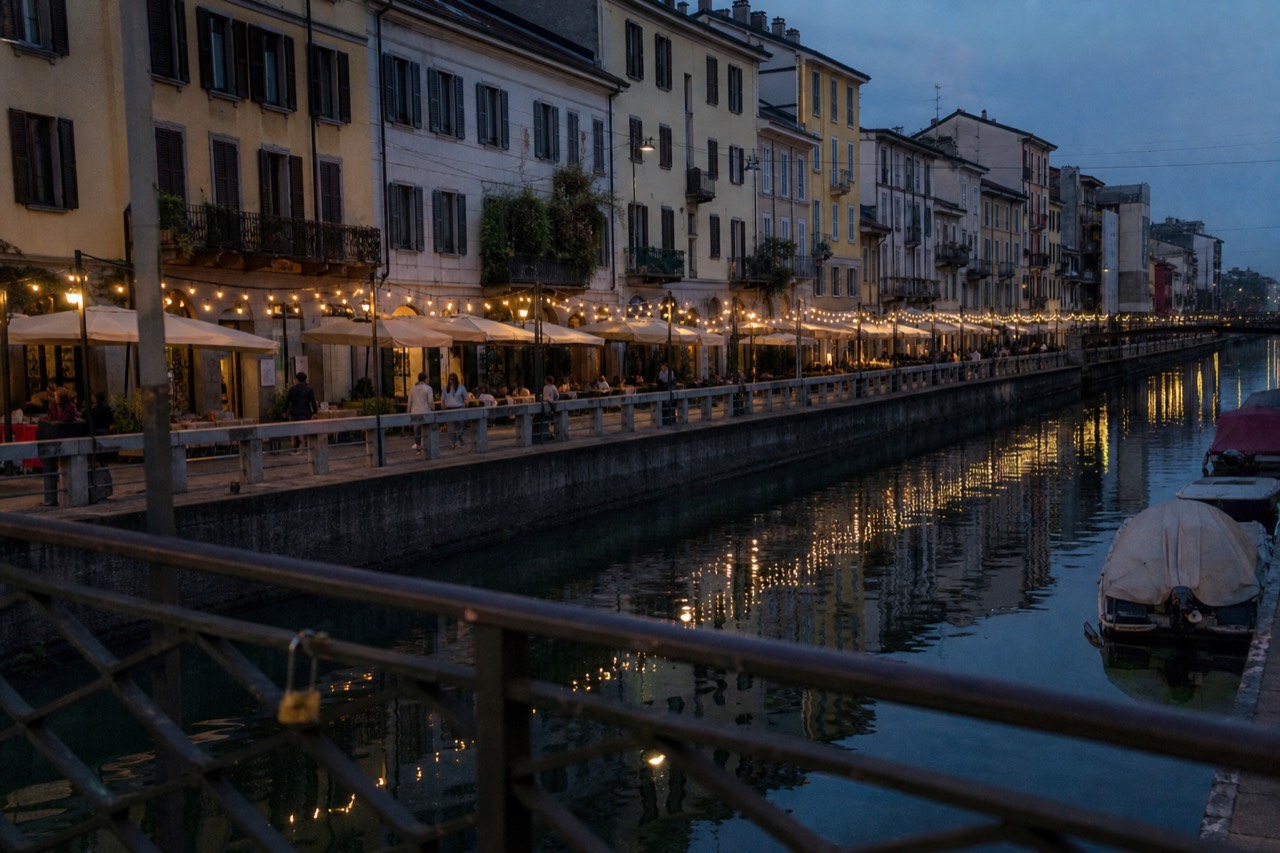 Evening tables and string lights along the Naviglio Grande canal in Milan