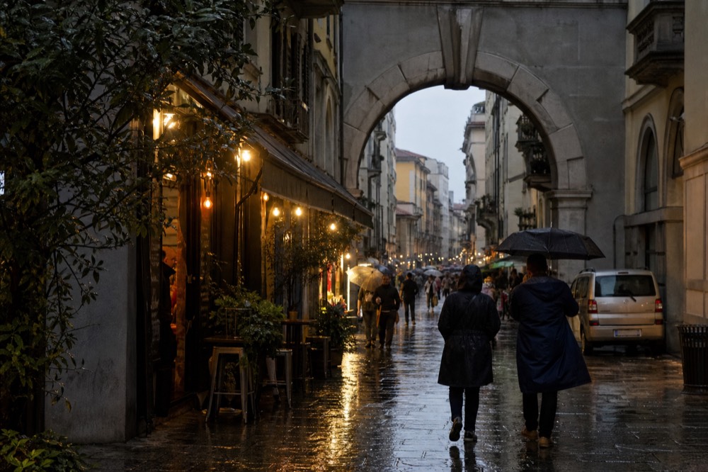 A busy pedestrian shopping street lined with small food shops and neon signs