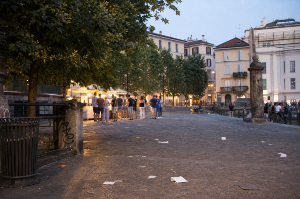 A small group standing at a Milan street food stall during a guided walk