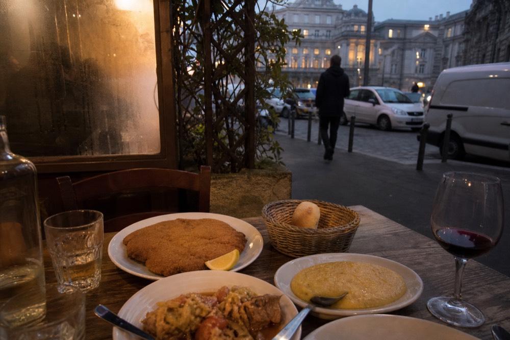 A collection of traditional Milanese dishes arranged on a rustic table